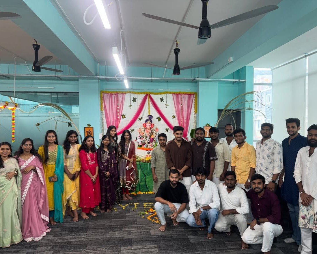 Team gathered around a decorated Ganesh display at the office
